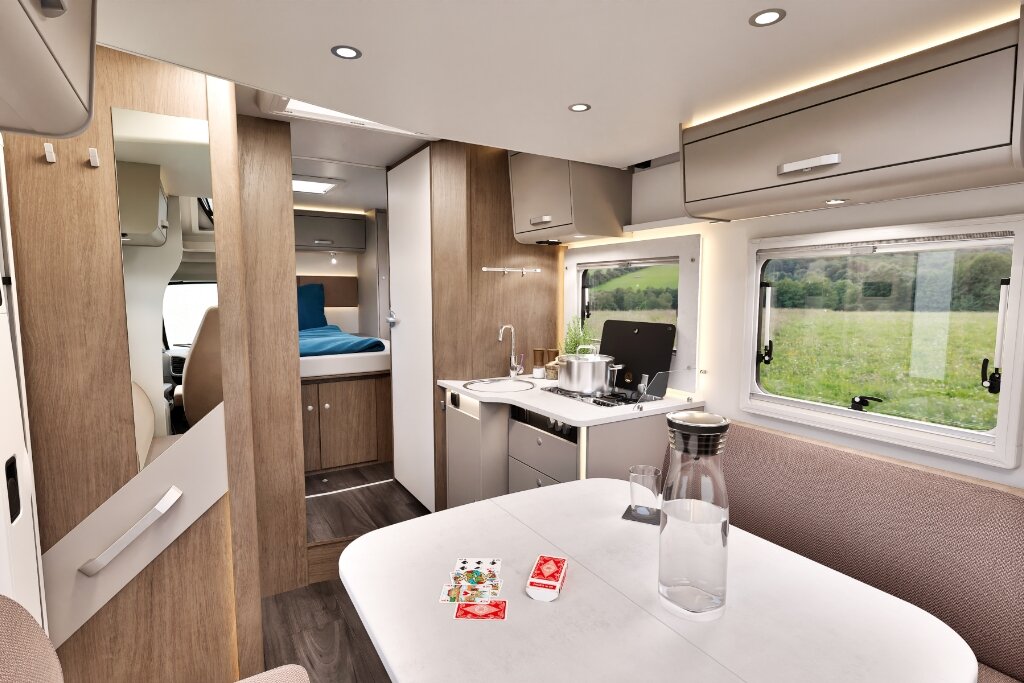 Carado motorhome interior with seating area, kitchen, windows and rear bed