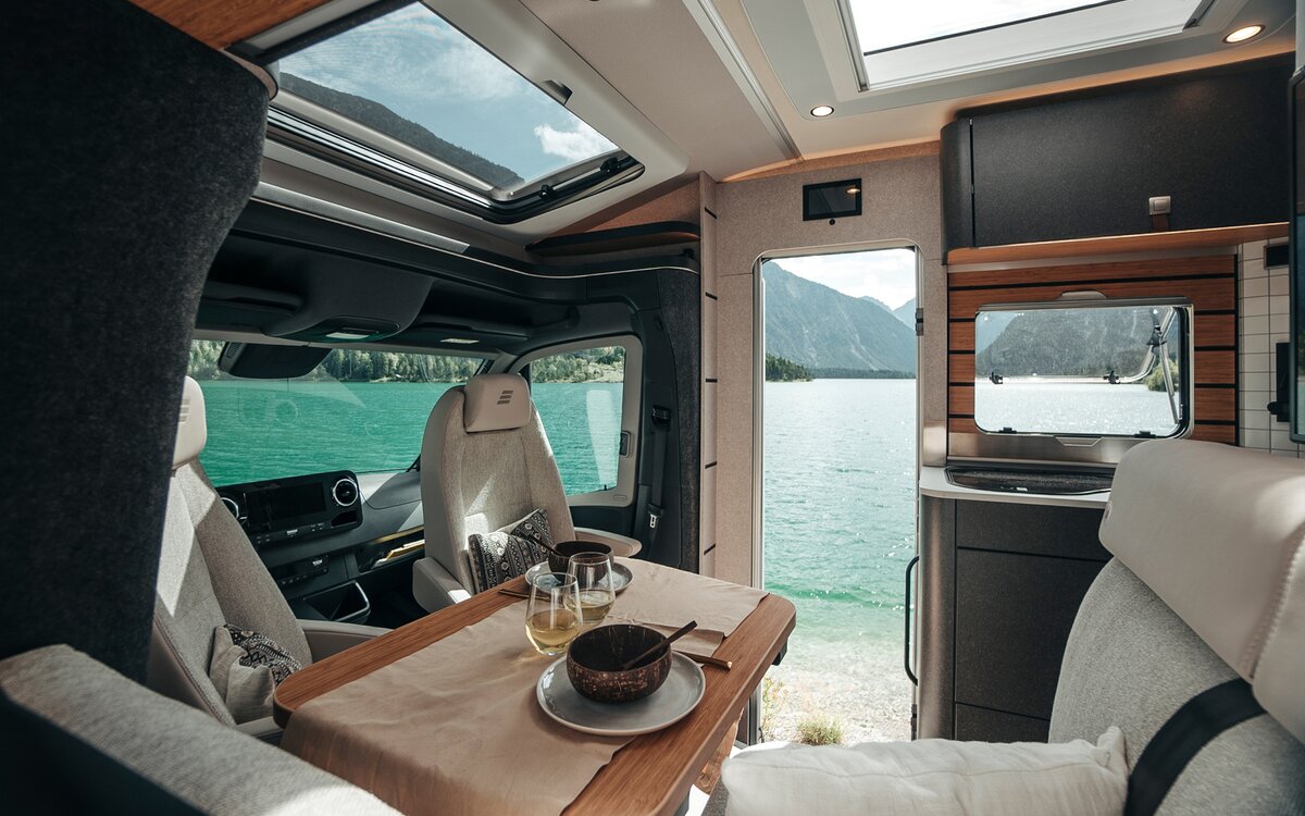 Genom att titta genom insidan av HYMER ML-T i stildesignen Native Bamboo möjliggör många fönster och dörrar utsikten över landskapet.