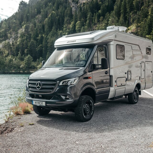 HYMER ML-T syns framifrån när den står framför en bergssjö.