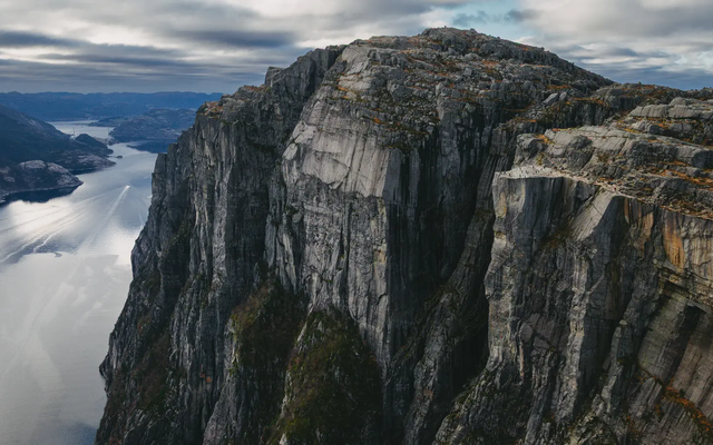 Uitzicht op een grote berg met een uitkijkplatform, fjord op de achtergrond links