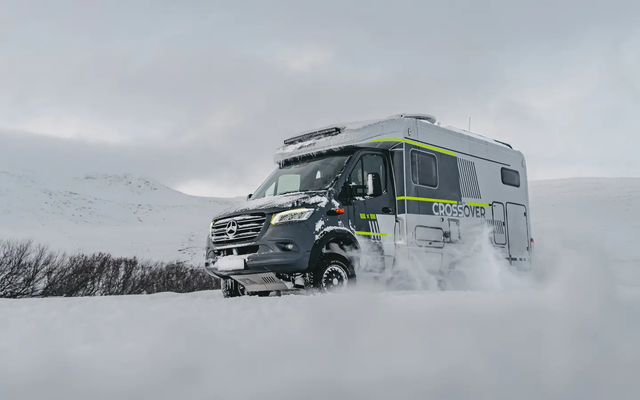 Diagonaal uitzicht van rechts voor op de HYMER ML-T 570 CrossOver, rijdend door een winterse sneeuwlandschap