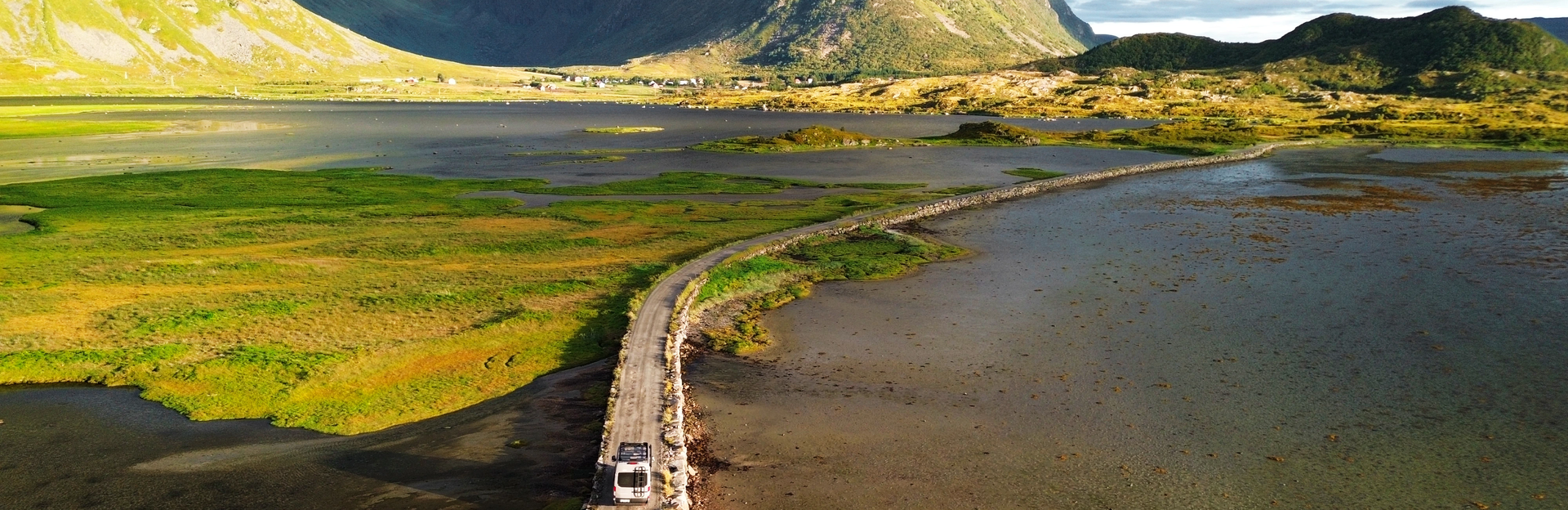 LMC Innovan Active aux îles Lofoten en Norvège. Route qui traverse les montagnes avec véhicule au milieu.